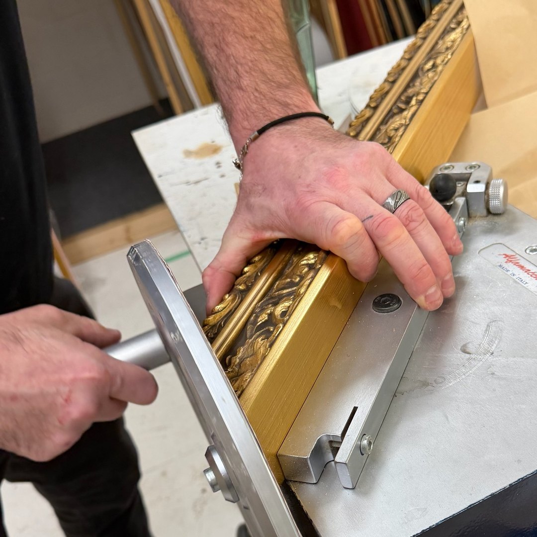 Hand-finishing a gold moulding on the bench